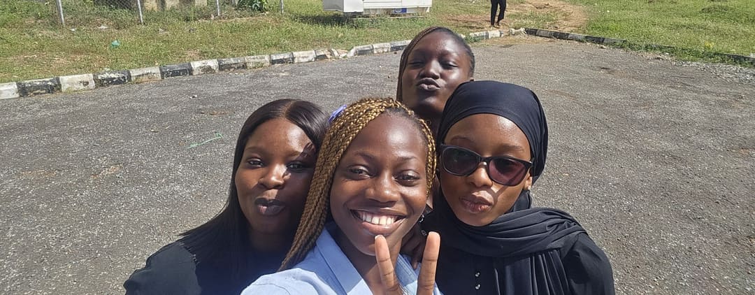 Four friends taking a selfie outside on campus