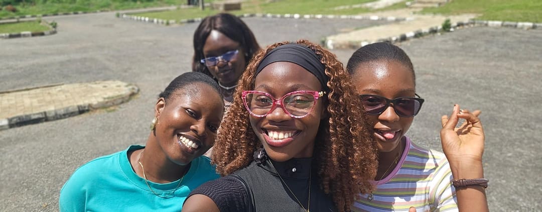 Four friends taking a selfie on a campus road