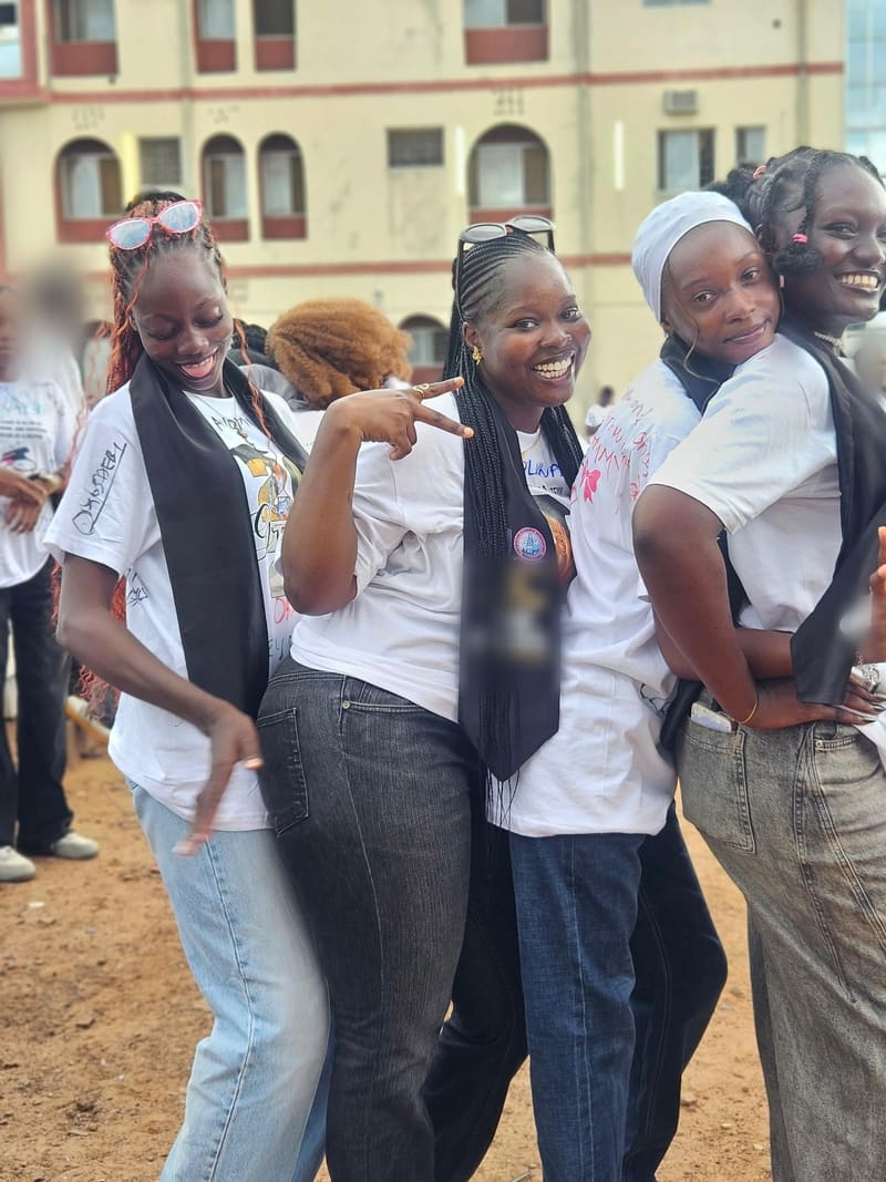Four friends in signed white shirts and sashes on sign-out day