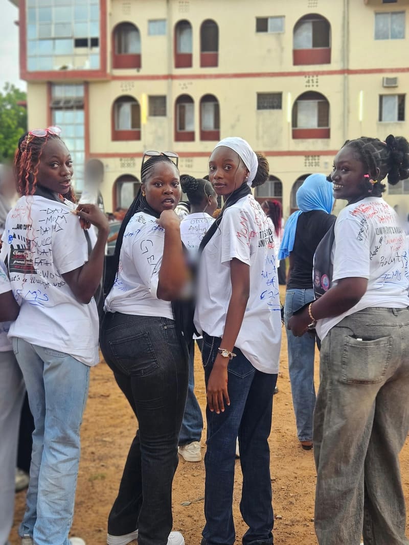 Four friends looking back over their shoulders in signed white shirts